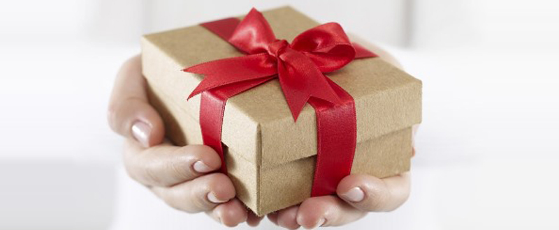Hand holding a brown gift box with red ribbon (Photo from Mashable.com)